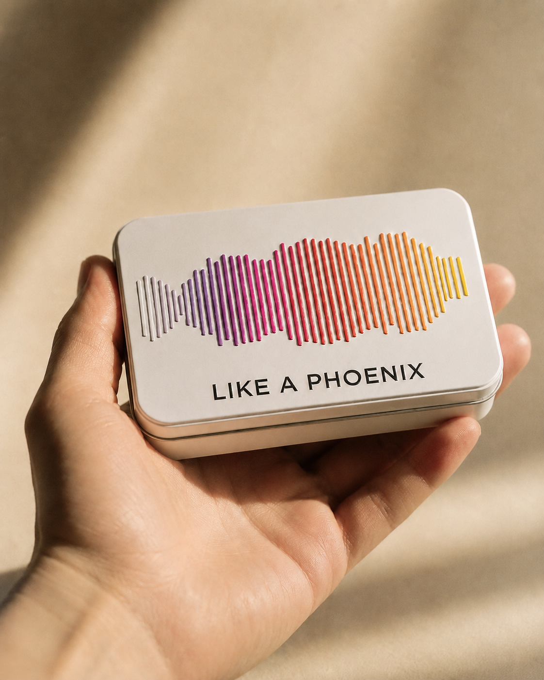 Open hand holding a small white tin with raised soundwave lid, warm side light